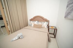 a small bedroom with a bed with a foot board at The Calm Coast Studio in Harqalah