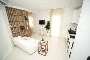 a white living room with a white couch and a table at The Calm Coast Studio in Harqalah
