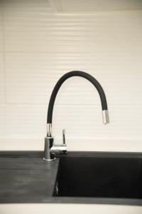 a kitchen sink with a faucet on a counter at The Calm Coast Studio in Harqalah