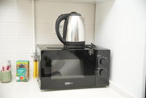 a coffee pot sitting on top of a microwave at The Calm Coast Studio in Harqalah +9 photos