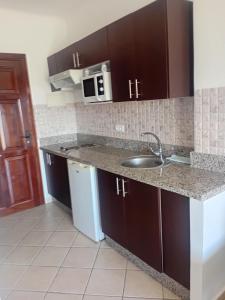 a kitchen with a sink and a microwave at Appart-Hotel Cabodream beach in Tétouan