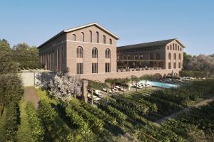 a building with a pool in front of a garden at Terra Saar, Weinresort & Spa in Saarburg