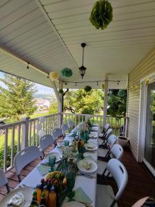 a long table on a porch with white tables and chairs at Bogdanówka in Skalnik