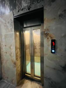 a glass door with a red light in a building at Hotel Grand Plaza - Gate No 3 Dlf Chattarpur Farms in New Delhi +16 photos
