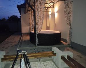 a bath tub on a patio at night at Kovács-Otthon in Vásárosnamény