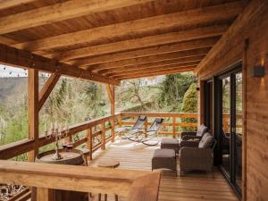 eine große Holzterrasse mit Stühlen und einem Tisch in der Unterkunft Romantikchalet Vogelnest mit Whirlpool, Kamin, Balkon & Terrasse in Vorra