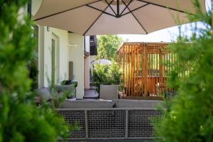a patio with an umbrella in front of a house at Osada Malawka pod Śnieżką - wypoczynek w saunie lub jacuzzi z widokiem na góry in Karpacz