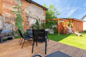 a patio with a table and chairs and a playground at Osada Malawka pod Śnieżką - wypoczynek w saunie lub jacuzzi z widokiem na góry in Karpacz