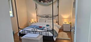 a bedroom with a four poster bed with a canopy at Chambre Zen Et Calme in Bouveret