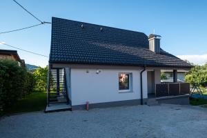 a small white house with a black roof at Mahne Apartment in Kranj