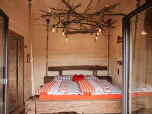 ein Bett in einem Holzzimmer mit Lichtern in der Unterkunft Romantikchalet Vogelnest mit Whirlpool, Kamin, Balkon & Terrasse in Vorra