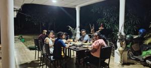 a group of people sitting at a table with food at Mango Oasis - Holiday Bangalow in Habarana