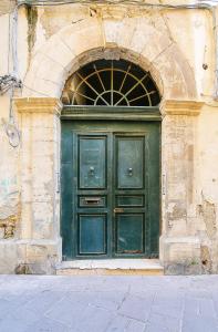 a green door on the side of a building at Fausto's House in Siracusa