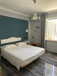 a bedroom with a large bed with a blue wall at B&B Ponza Suite in Ponza