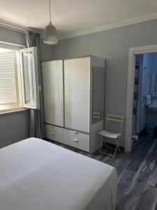 a bedroom with a white bed and a chair at B&B Ponza Suite in Ponza