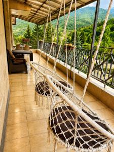 a balcony with two rattan chairs and a view at Riverside Penthouse in Dilijan in Dilijan