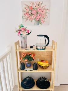 a small wooden shelf with a blender and flowers at The Trinity - Double Room Suite 1 with Study and En-suite in High Wycombe