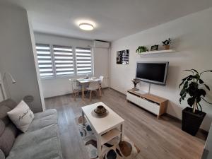 a living room with a couch and a tv and a table at Studio apartment Cascada in Plitvička Jezera