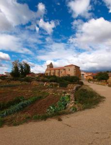 a building on the side of a hill with a road at Casa Ti Mielga in Ayoó de Vidriales