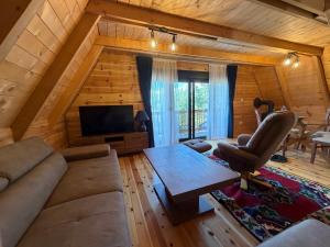 a living room with a couch and a table in a cabin at Durmitor Den in Žabljak