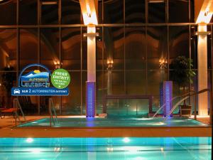 a large building with a swimming pool in front of it at Bergfrieden Leutasch/Seefeld in Leutasch