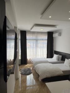 a bedroom with two beds and a large window at Sarajevo Center Point in Sarajevo