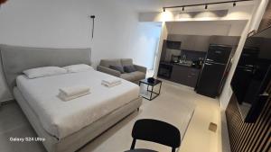 a bedroom with a bed and a chair and a kitchen at סי סייד אילת חדר משפחתי מפנק עם נוף לים in Eilat