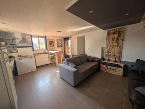 a living room with a couch and a kitchen at La cascade de Grignon - Appartement - Pizzeria - Parking Vélos - Room Service in Grignon