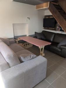 a living room with a couch and a table at La cascade de Grignon - Appartement - Pizzeria - Parking Vélos - Room Service in Grignon