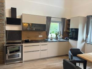 a kitchen with white cabinets and a table and a window at SchiScho's Lodge in Sankt Kathrein am Offenegg +34 photos