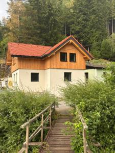 a house with a wooden bridge in front of it at SchiScho's Lodge in Sankt Kathrein am Offenegg