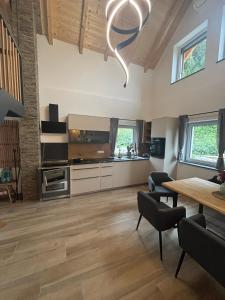 a large living room with a table and a kitchen at SchiScho's Lodge in Sankt Kathrein am Offenegg