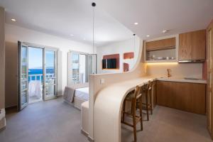 a kitchen and bedroom with a bed and a view of the ocean at Gea Perla Serifos in Livadi