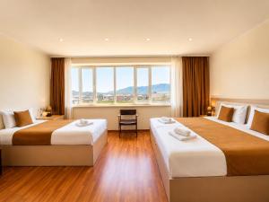 a hotel room with two beds and a large window at Hotel Basen in Sisian