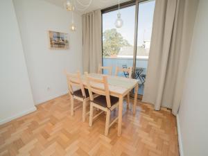 ein Esszimmer mit einem Tisch, Stühlen und einem Fenster in der Unterkunft OPORTO GUEST Wine Experience Flat in Porto