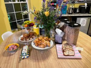 a table with plates of pastries and bread on it at Whispering Oak Mansion in Bear