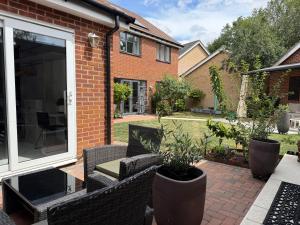 a patio with chairs and plants in front of a house at The Hideaway - Secluded Studio Annexe in Cambourne