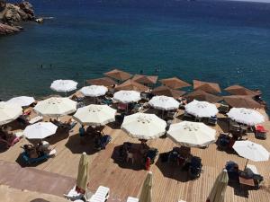 a group of umbrellas on a beach with the water at Lazarou Beach Apartments in Platis Yialos Sifnos