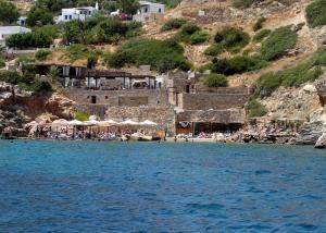 a beach with umbrellas and people on the water at Lazarou Beach Apartments in Platis Yialos Sifnos