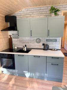 a kitchen with white cabinets and a counter top at Ubytovanie Lišov 3 - Tiny House in Lišov +25 photos