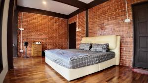 a brick room with a bed against a brick wall at Samwise Escapade Hillside Guesthouse - Master Room in Kampong Perlis