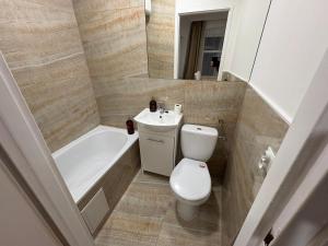 ein Badezimmer mit Toilette, Badewanne und Waschbecken in der Unterkunft Whisper Studio in Lębork + 6 Fotos