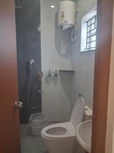 a bathroom with a toilet and a sink and a shower at Babus Serviced Apartments in Coimbatore +27 photos