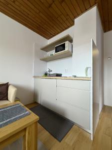 a kitchen with white walls and a counter with a microwave at Apartmány Hrady in Zuberec