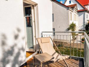 a chair sitting on the balcony of a house at SCHEE Apartments - stilvolle & zentrale Wohnungen mit Privatparkplatz in Nördlingen