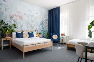 a bedroom with two beds and a floral wallpaper at Hotel Botanica by goodnite cz in Brno