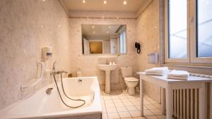 a bathroom with a tub and a toilet and a sink at Hotel Du Nord in Besançon +62 photos