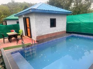 a small house with a swimming pool next to a building at Himjoy farm in Dādo Sība