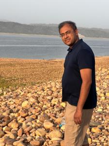 a man is standing on a pile of rocks at Himjoy farm in Dādo Sība