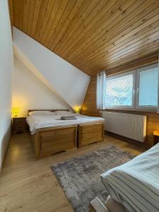 a bedroom with two beds and a large window at Apartmány Hrady in Zuberec